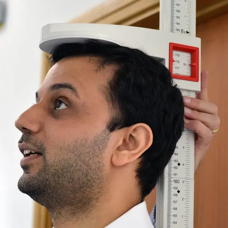 An employee having their height measured as part of employee health checks