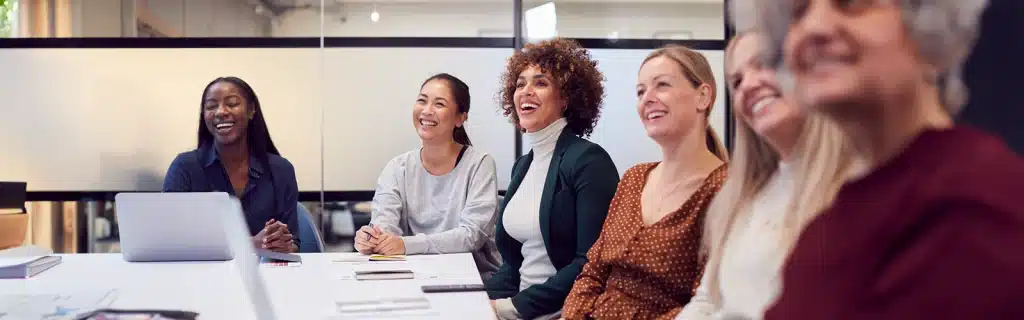 A group of diverse women gathered in a meeting room to celebrate World Menopause Day at Work