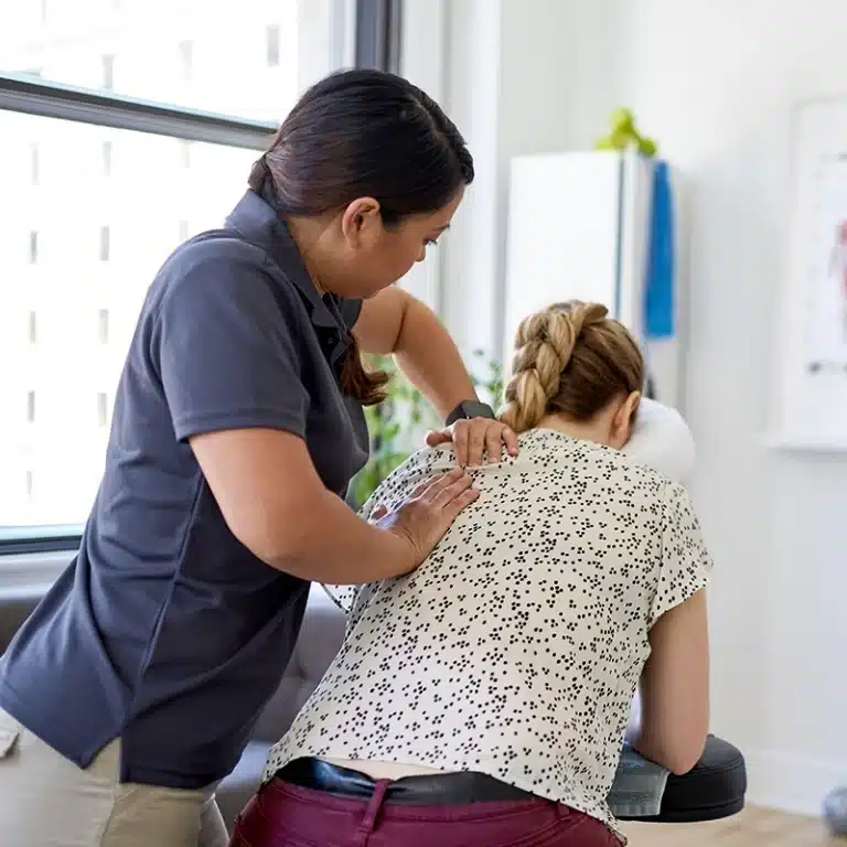 A masseuse giving an employee a massage as part of a workplace massage service