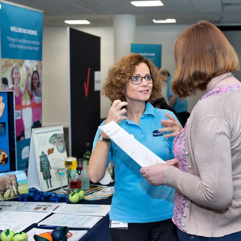 A New Leaf Health practitioner speaking to an attendee at a health and wellbeing roadshow