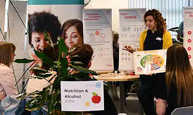 A group of employees listening to a New Leaf Health practioner hosting a workshop around nutrition and alcohol