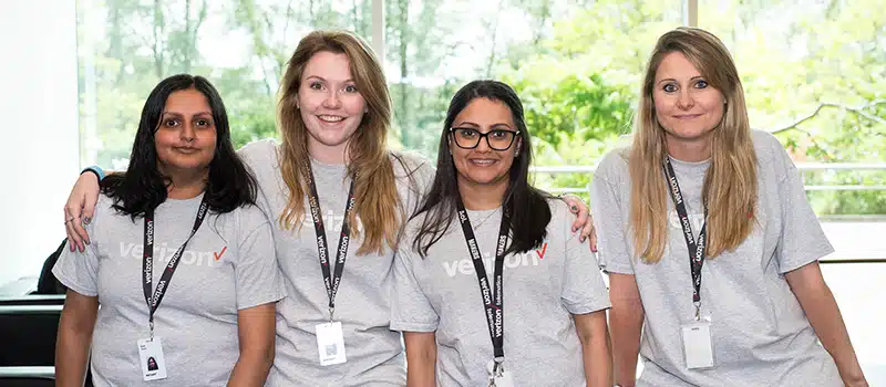 A group of Workplace Wellbeing Champions posing together and smiling whilst looking at the camera.