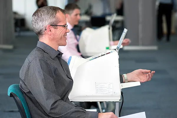 A man using a blood pressure machine takng part in an employee health check