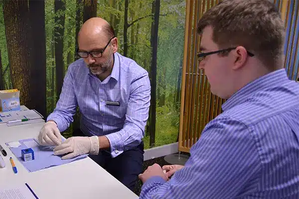 A New Leaf Health practitioner performing an employee vitamin D test on an attendee