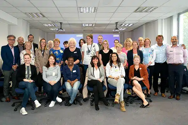 A group of managers smiling at the camera having taken part in manager mental health training
