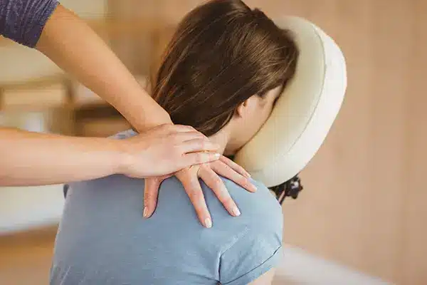 An woman sitting in a special massage chair receiving a workplace chair massage