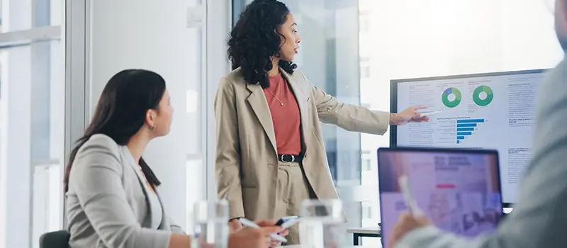 A group of HR staff discussing MHFA programme stats during a meeting