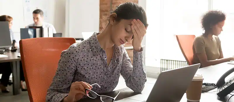 An unwell employee in the workplace experiencing presenteeism