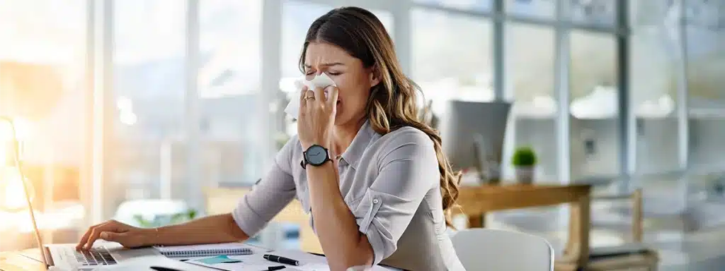 A woman suffering flu symptoms having not attended a workplace flu clinic