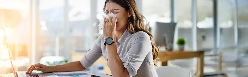 A woman suffering flu symptoms having not attended a workplace flu clinic