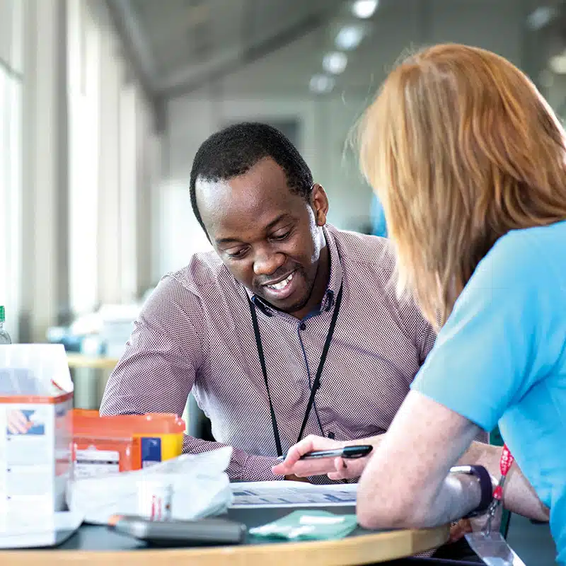 A man engaged in a workplace health screening with a New Leaf Health practitioner