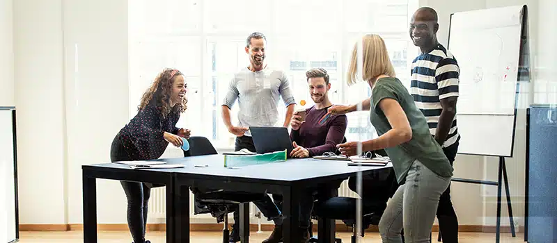 A group of employees playing table tennis as part of a workplace wellbeing programme