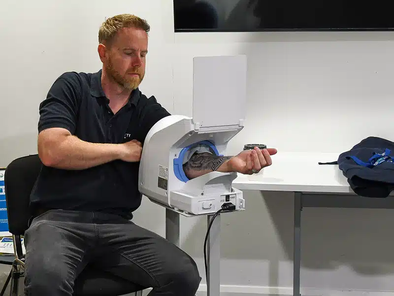 A man using a blood pressure machine as part of a New Leaf Health employee health check