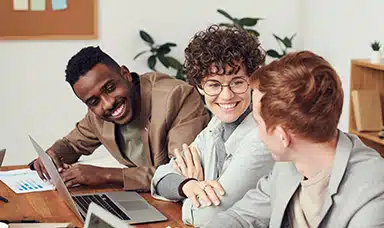 A group of employees smiling and discussing positive mental health