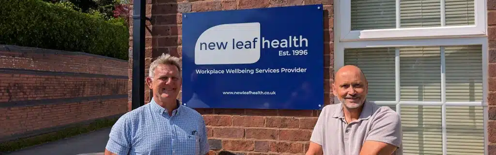 Phil Olding and Andy Lee-O'Neil standing in front of the New Leaf Health building sign