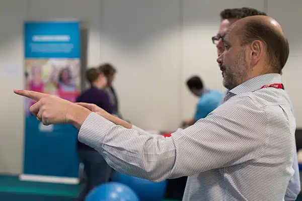 Andy from New Leaf Health talking to an attendee at an on-site workplace wellbeing event