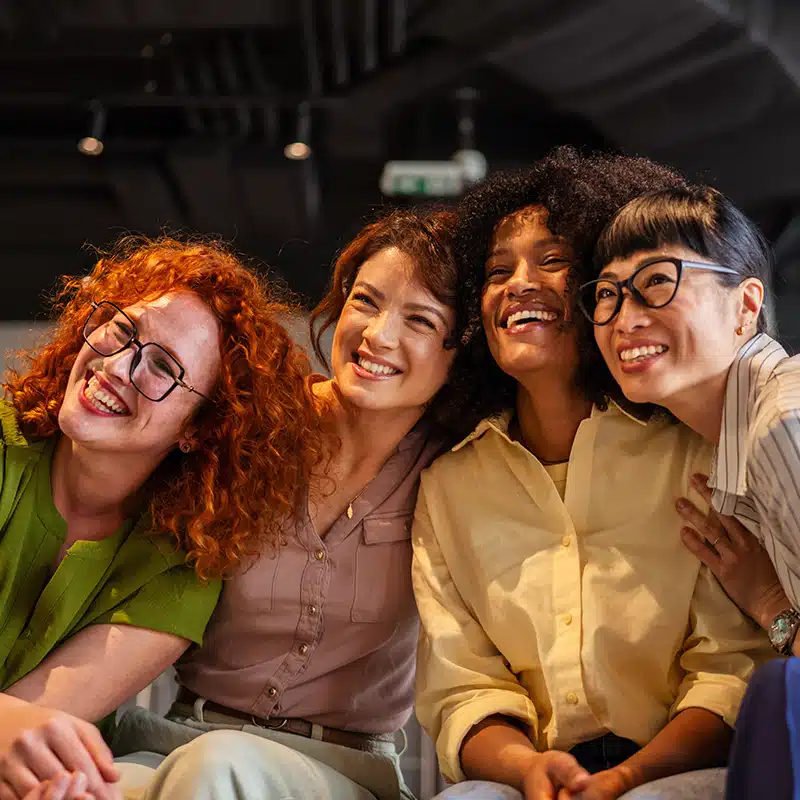 A group of menopause age women laughing and smiling at something off camera