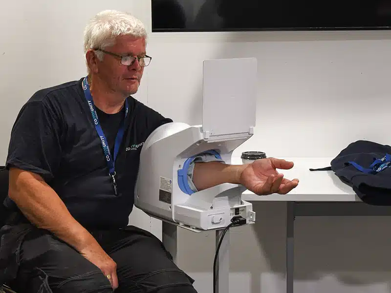 An employee testing their blood pressure as part of an employee health screening