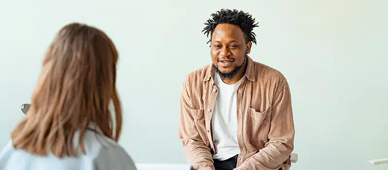 Two colleagues having a conversation using workplace mental health frameworks
