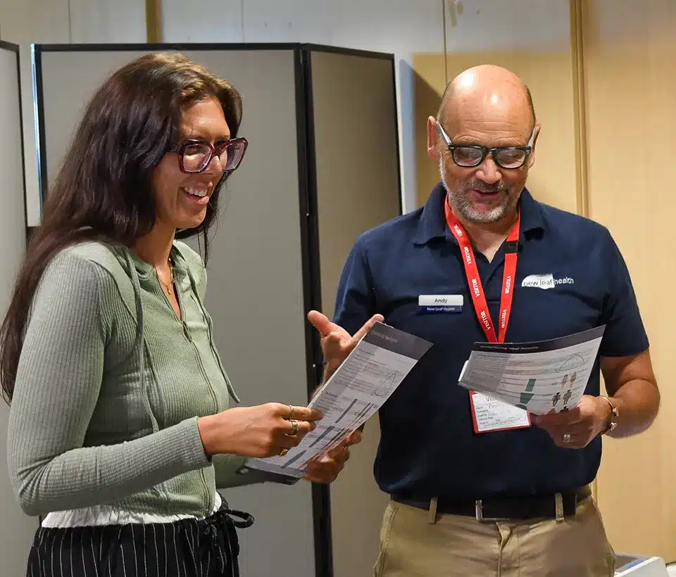 A New Leaf Health practitioner chatting with an attendee at a health check event